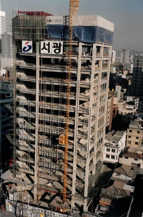 골조가 올라간 고층 건물과 주변 도심 전경