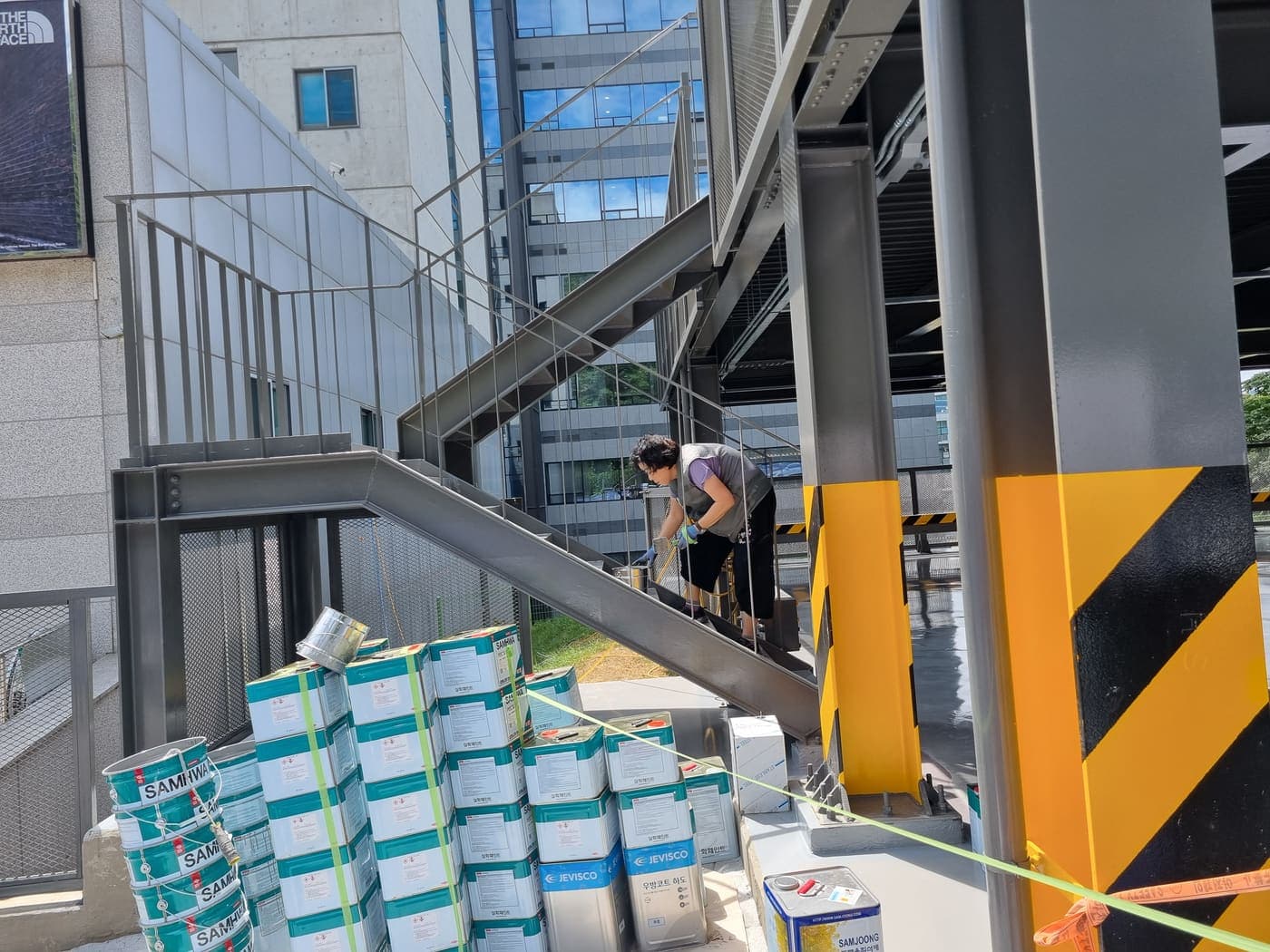 계단 옆에 적재된 바닥 도장용 페인트 자재